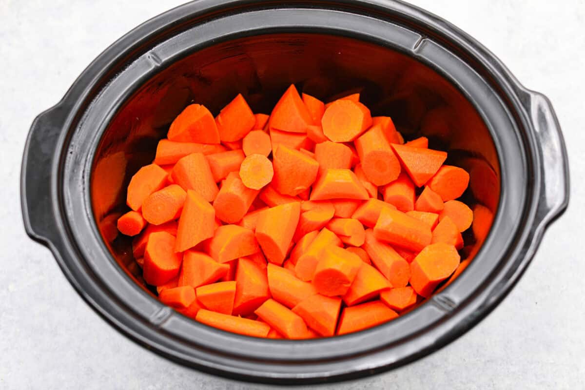 Overhead shot of cut up carrots in a crockpot. 