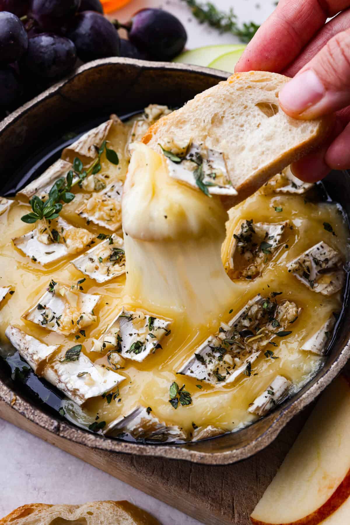 Close up shot of someone scooping up a bite of baked brie. 