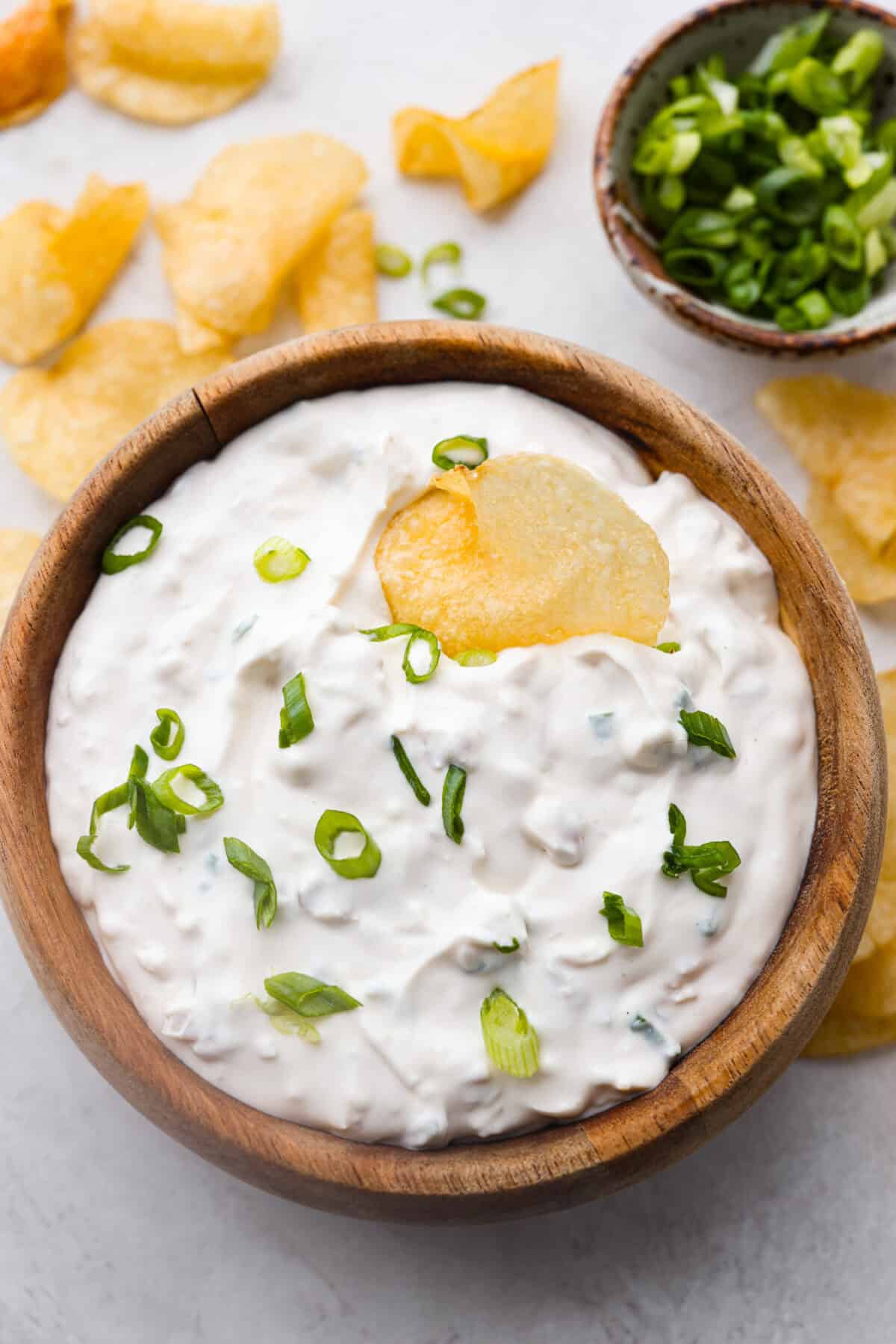 Overhead shot of a wooden bowl with clam dip inside. 