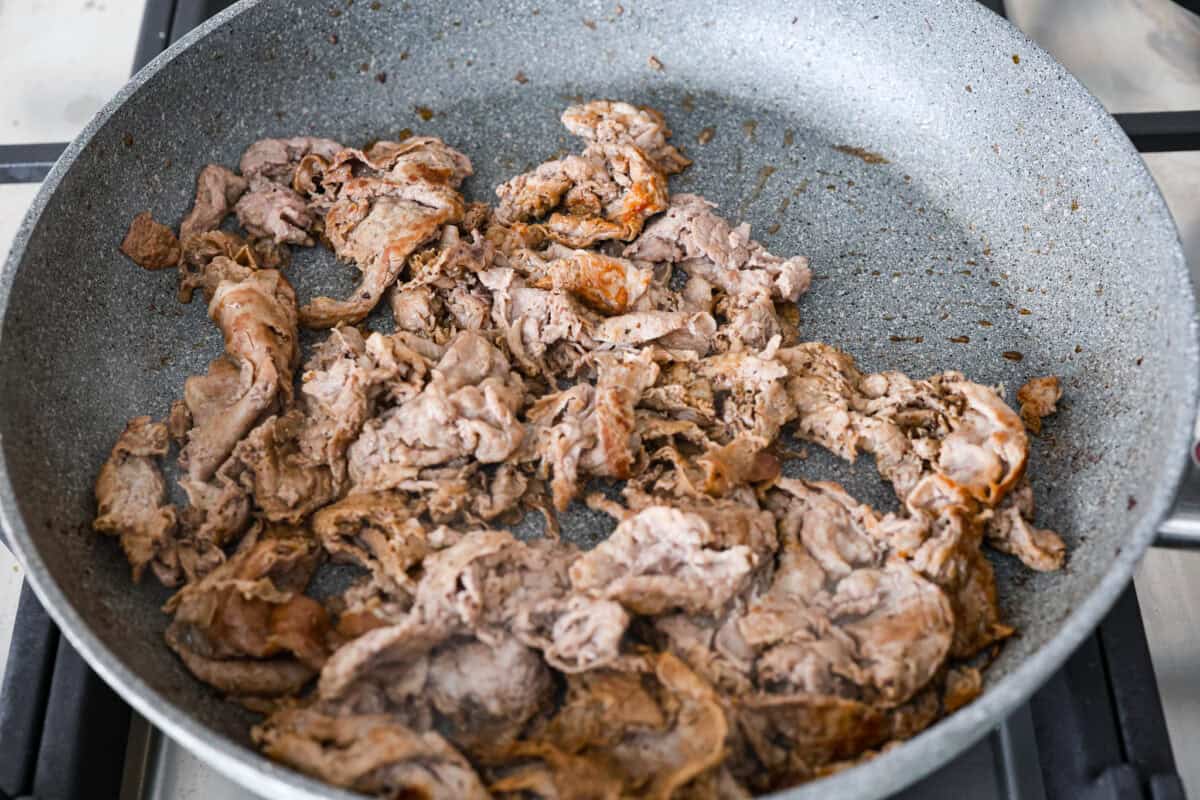 Overhead shot of beef cooking in a skillet. 