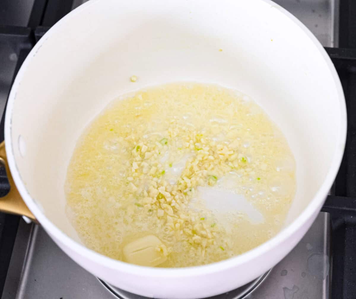 Overhead shot of melted butter with garlic in a pot. 