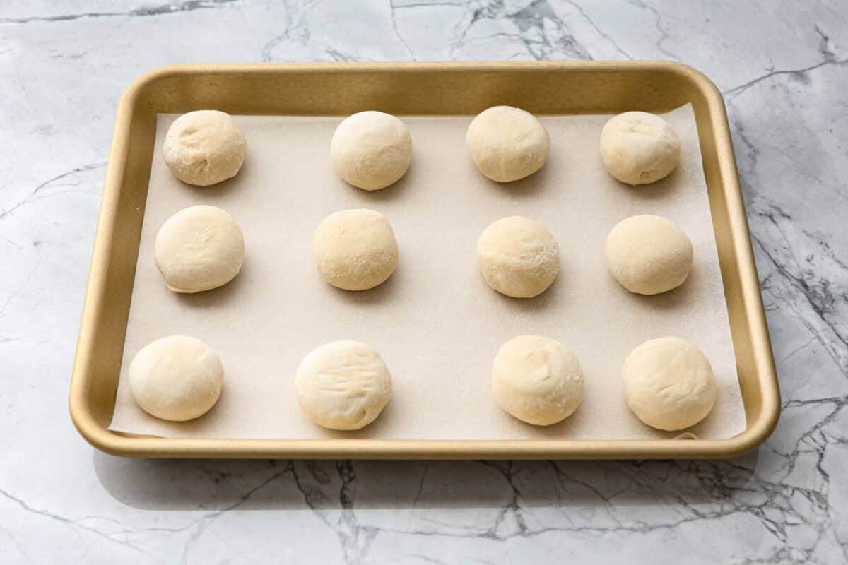 Angle shot of frozen dough balls on a cookie sheet. 