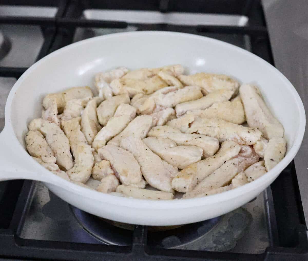 Second photo of the chicken browning in the skillet.