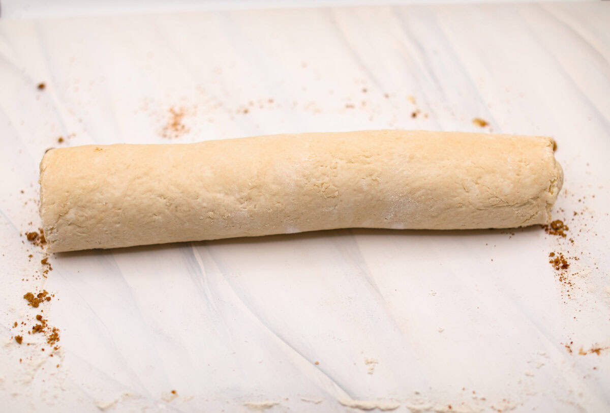 Overhead shot of the biscuit cinnamon roll dough into a cylander. 