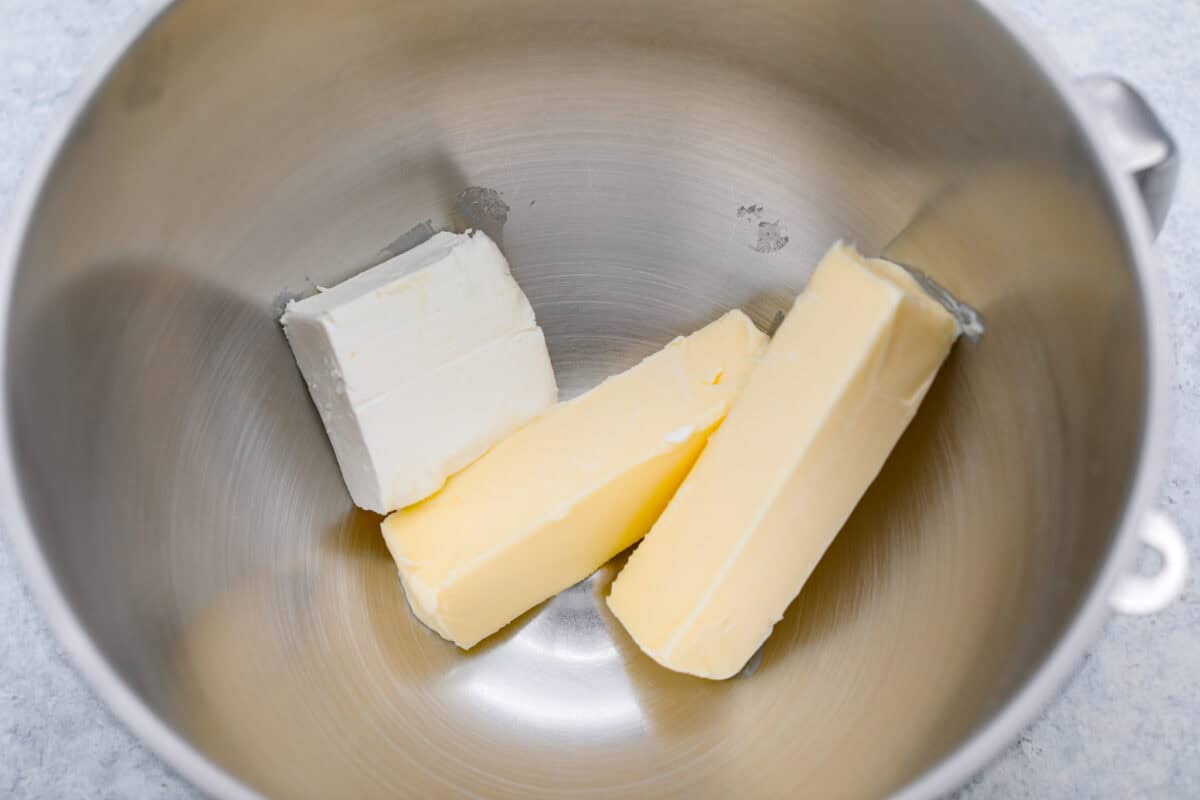 Overhead shot of butter and cream cheese in a mixing bowl. 