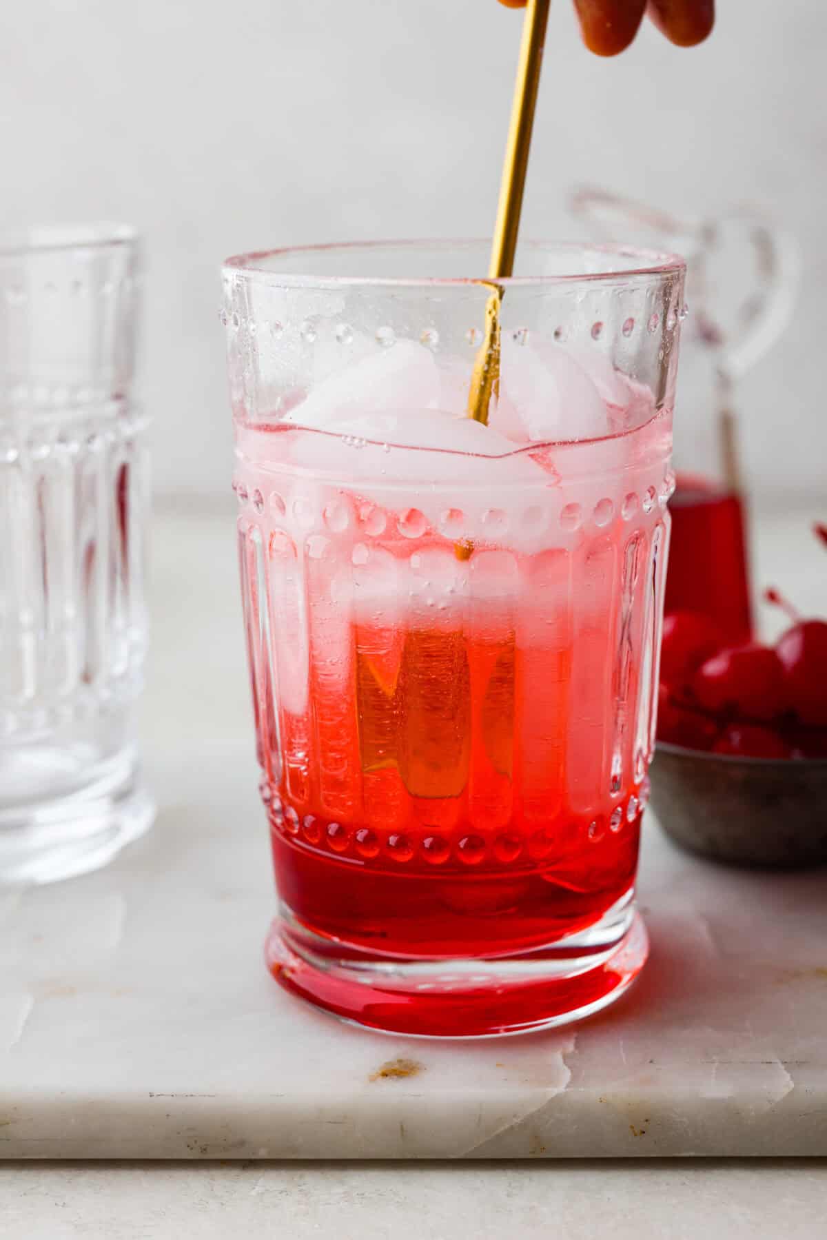 Side shot of someone stirring the Shirley Temple. 