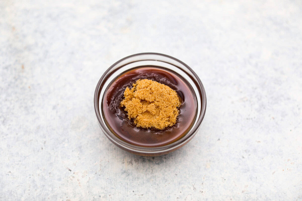 Overhead shot of bbq sauce, brown sugar and maple syrup in a bowl.