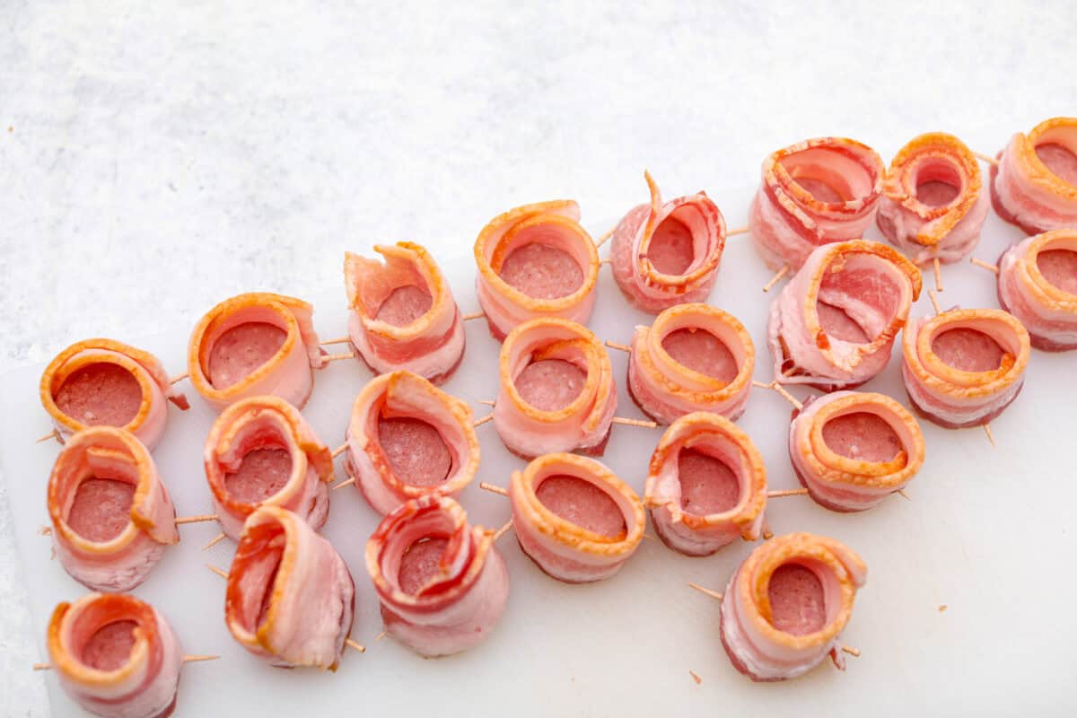 Overhead shot of all of the slices of sausage wrapped in bacon. 