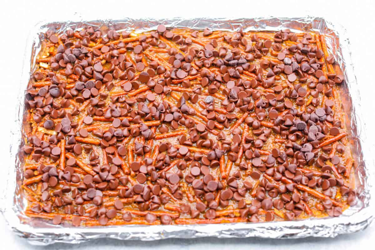 Overhead shot of chocolate chips sprinkled over baking sheet. 