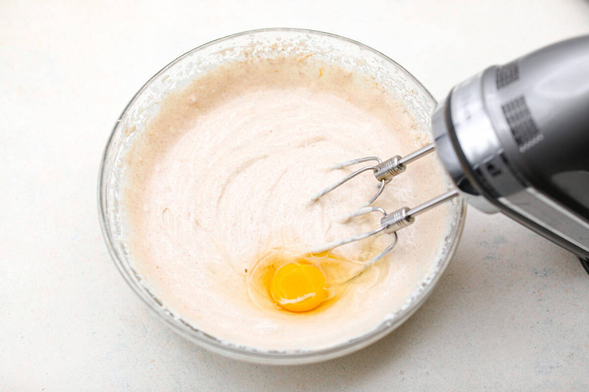 Overhead shot of the ricotta and other ingredients mixed together with an egg on top. 