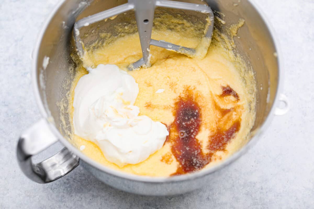 Overhead shot of sour cream and vanilla on top of the butter sugar and egg mixture. 