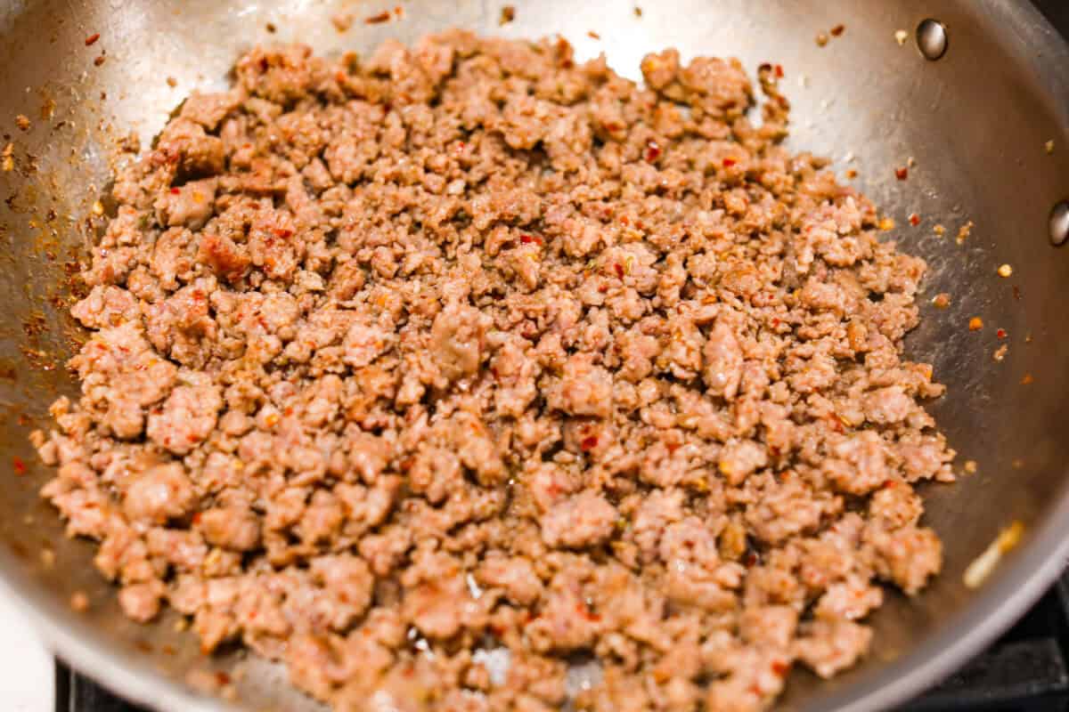 Overhead shot of the Italian sausage cooking in a skillet. 