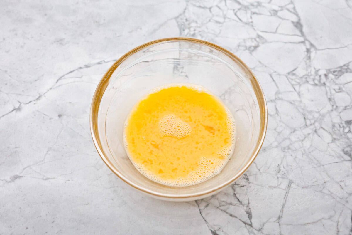 Overhead shot of eggs whisked in a bowl. 