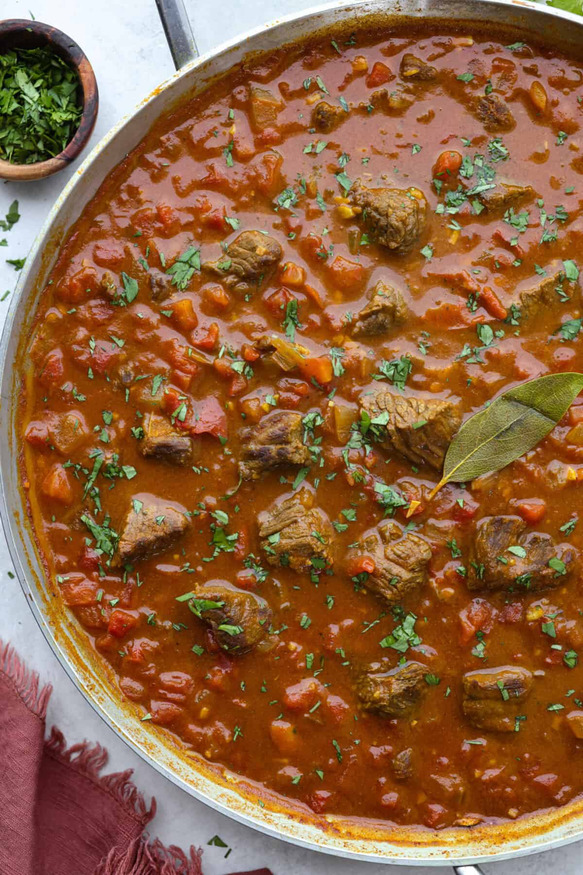 Overhead shot of beef curry in a skillet. 