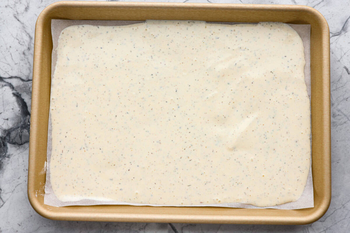 Overhead shot of the whipped up ingredients spread out on a parchment paper in a cookie sheet.