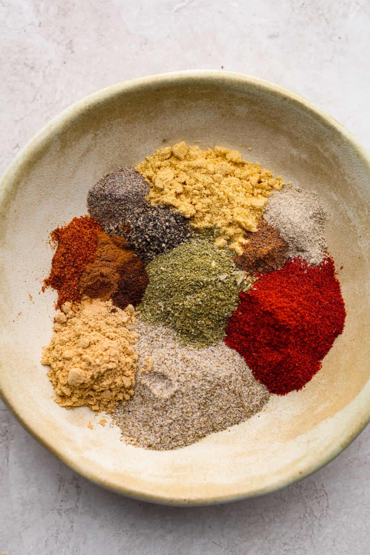 Overhead shot of all of the homemade old bay seasoning ingredients divided up on a plate. 