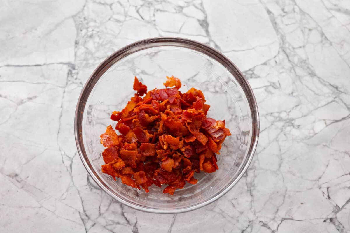 Overhead shot of cooked bacon  pieces in a bowl. 